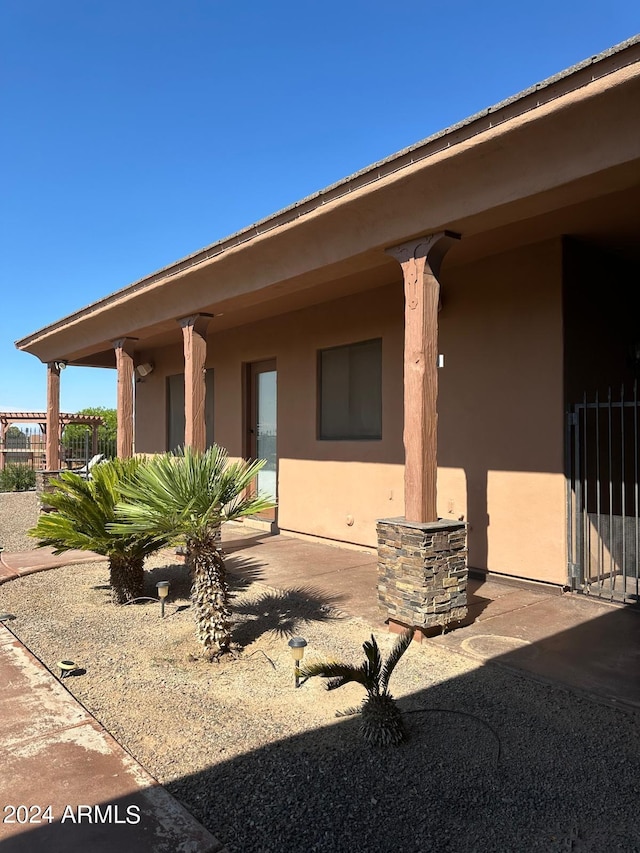 rear view of house featuring stucco siding