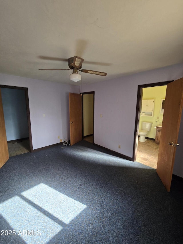 unfurnished bedroom featuring ensuite bathroom, ceiling fan, carpet, and baseboards