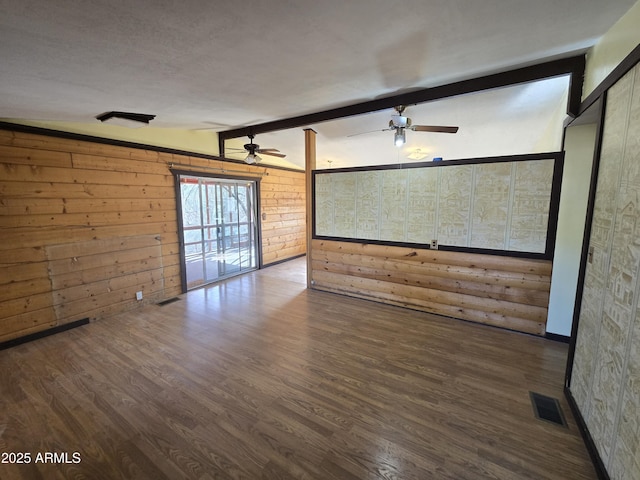 unfurnished living room with lofted ceiling with beams, ceiling fan, wood finished floors, and visible vents