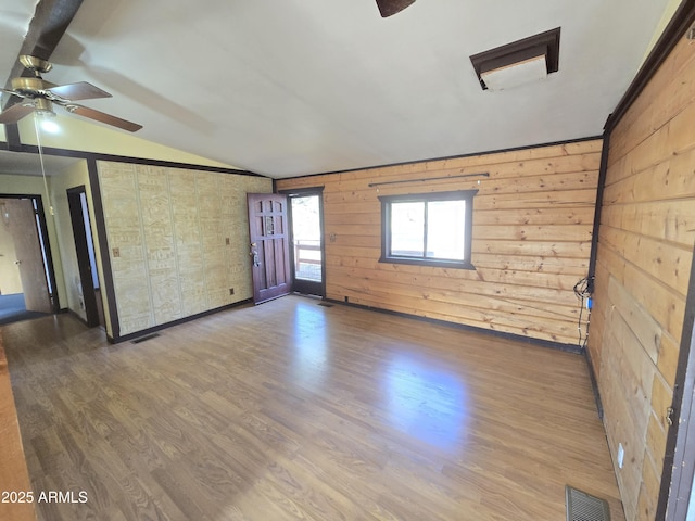 unfurnished room featuring lofted ceiling, ceiling fan, visible vents, and wood finished floors