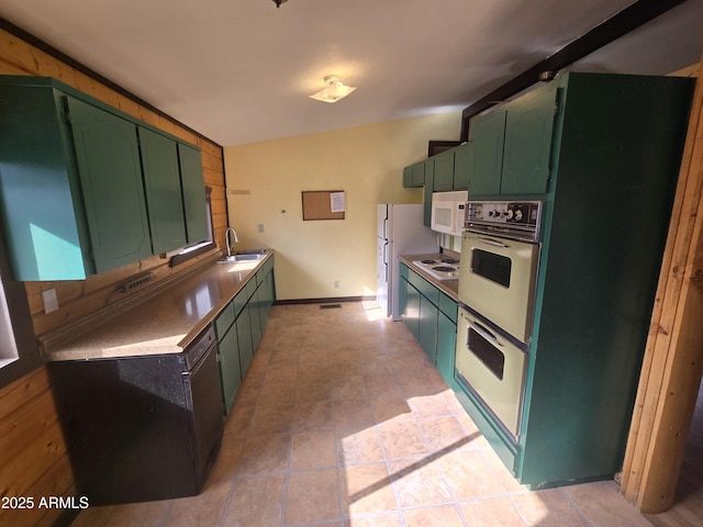 kitchen featuring green cabinets, light tile patterned flooring, a sink, white appliances, and baseboards