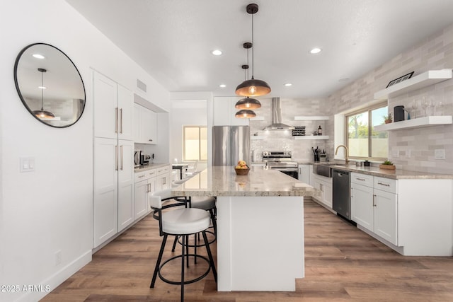 kitchen featuring stainless steel appliances, range hood, and white cabinets