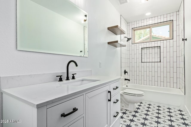 full bathroom featuring vanity, tiled shower / bath combo, and toilet