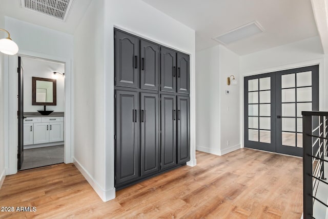 foyer entrance with light hardwood / wood-style floors and french doors