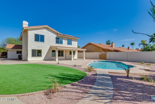 back of house with a fenced in pool, a yard, a patio area, and central air condition unit