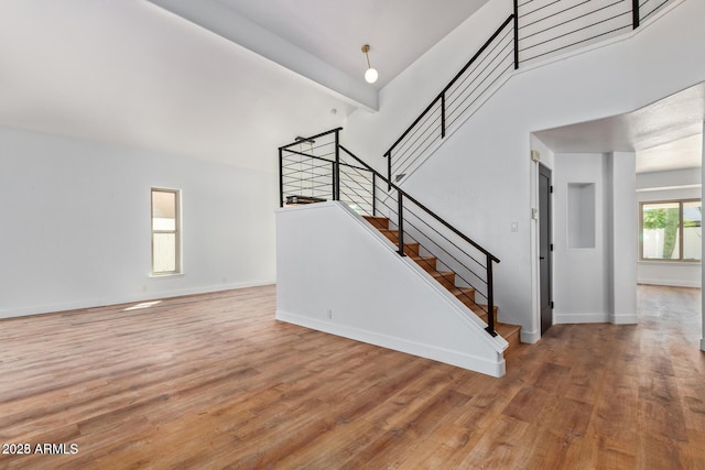 staircase with beam ceiling and hardwood / wood-style floors