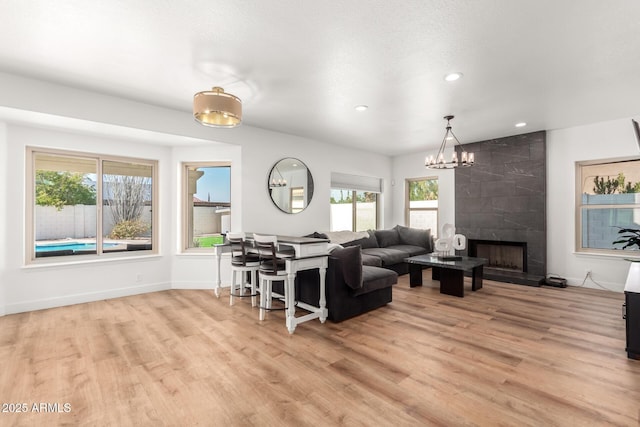 living room with a fireplace, light hardwood / wood-style floors, and a chandelier