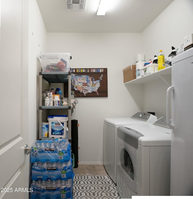 clothes washing area with light tile patterned flooring, laundry area, independent washer and dryer, and visible vents