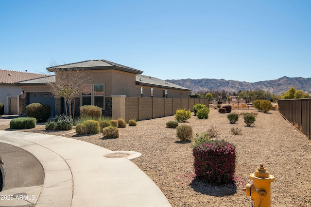 view of yard featuring a mountain view, fence private yard, and an attached garage