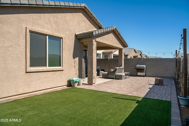 exterior space with outdoor lounge area, a fenced backyard, and a grill