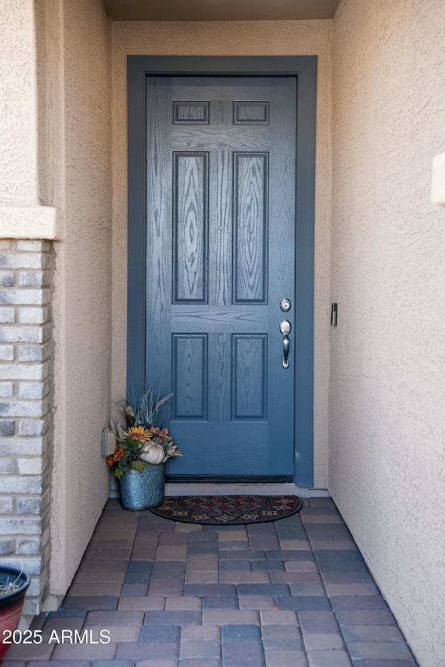 entrance to property featuring stucco siding