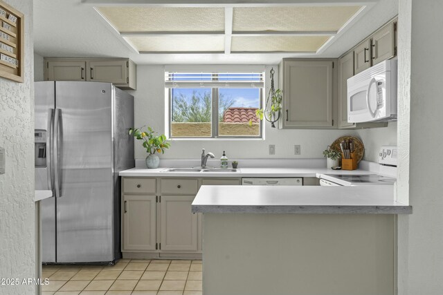 kitchen featuring brown cabinets, a sink, white appliances, and light countertops