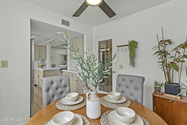 kitchen featuring a sink, brown cabinetry, ceiling fan, light countertops, and freestanding refrigerator