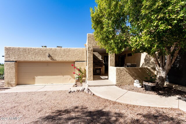 view of home's exterior featuring stucco siding, an attached garage, and gravel driveway