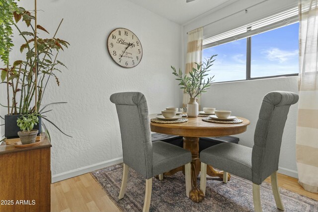 dining area with light wood-style floors, baseboards, and ceiling fan