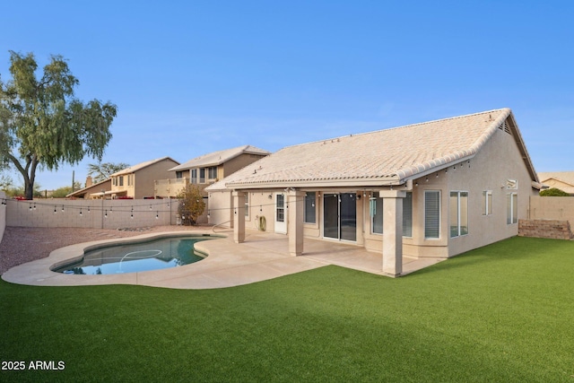 back of house with a fenced in pool, a yard, and a patio area