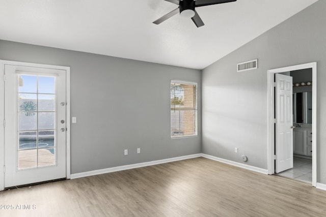 spare room featuring ceiling fan, lofted ceiling, and light hardwood / wood-style flooring