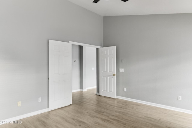 unfurnished bedroom featuring hardwood / wood-style flooring, ceiling fan, and high vaulted ceiling