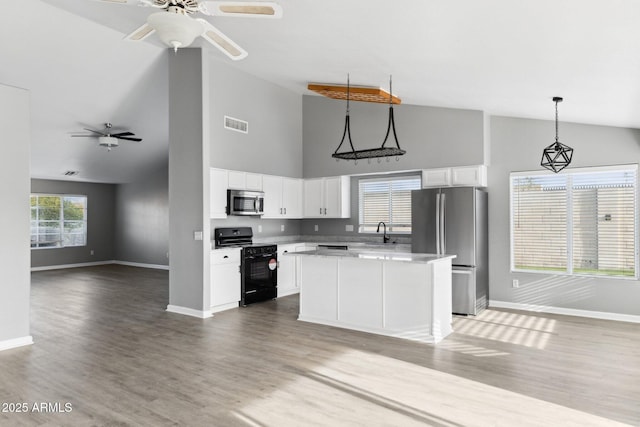 kitchen featuring sink, white cabinetry, a center island, appliances with stainless steel finishes, and pendant lighting