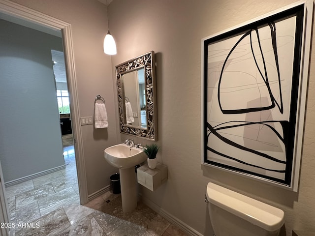 bathroom with toilet and baseboards