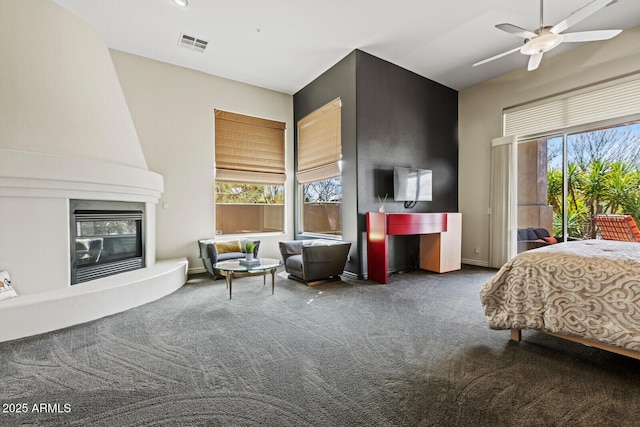 carpeted bedroom with visible vents, multiple windows, a large fireplace, and access to exterior