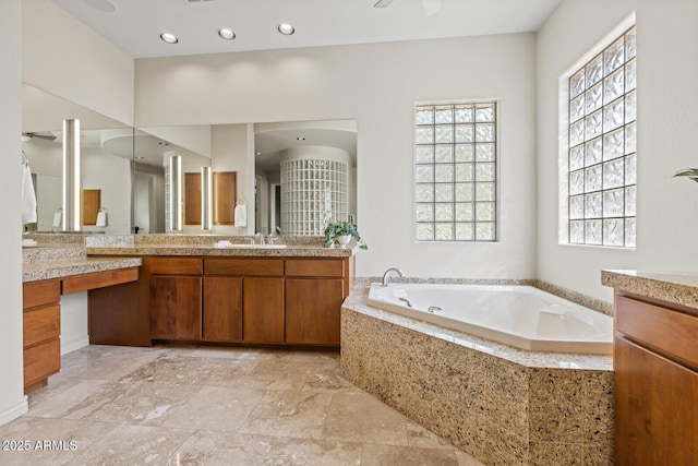 full bath featuring vanity, a garden tub, and recessed lighting