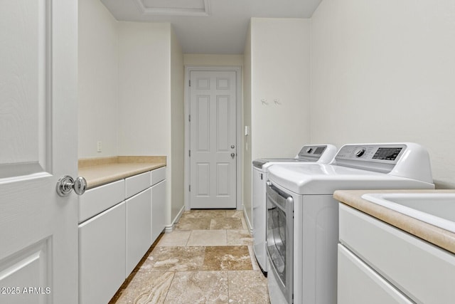 laundry room with cabinet space, stone finish floor, and washing machine and dryer