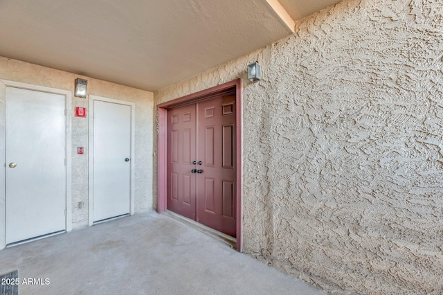 view of exterior entry featuring stucco siding