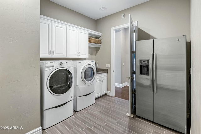 2051 E Aris Dr, Gilbert, AZ 85298 - laundry area featuring washing machine and dryer, baseboards, wood finish floors, and cabinet space