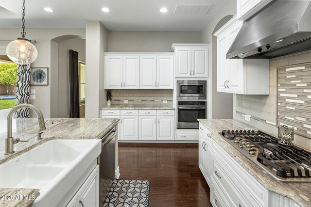 2051 E Aris Dr, Gilbert, AZ 85298 - kitchen with stainless steel appliances, a sink, visible vents, backsplash, and wall chimney range hood
