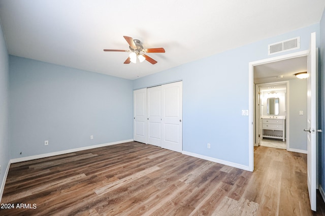 unfurnished bedroom with hardwood / wood-style floors, ceiling fan, and a closet