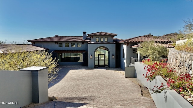 mediterranean / spanish-style home with a tiled roof and stucco siding