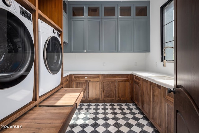 clothes washing area with cabinets, sink, and washing machine and dryer