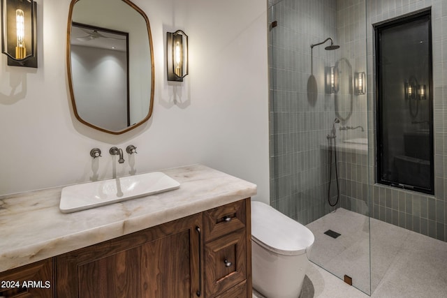 bathroom featuring vanity, toilet, and a tile shower