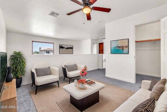 carpeted living room featuring baseboards, a ceiling fan, and visible vents