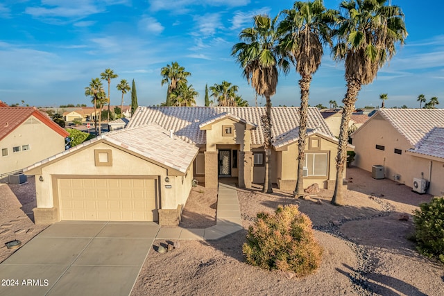 view of front of home with central air condition unit and a garage