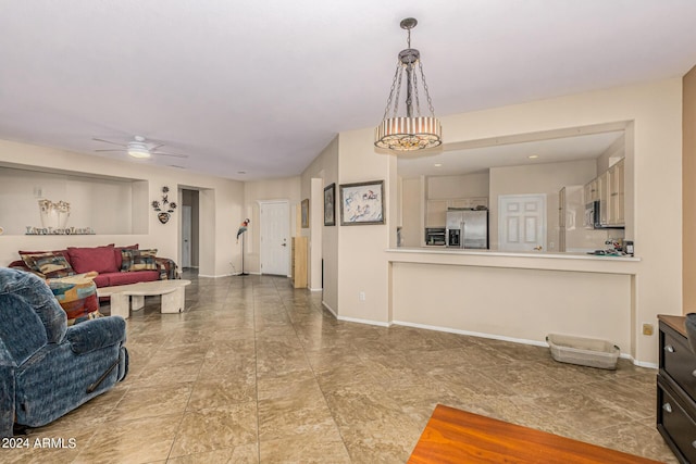 living area featuring ceiling fan and baseboards