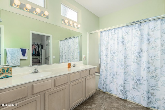 bathroom featuring double vanity, tile patterned floors, curtained shower, a spacious closet, and a sink