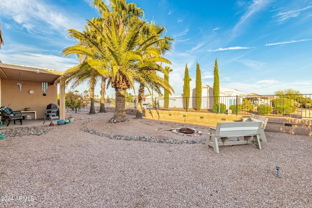 view of yard with a fire pit, a patio, and fence