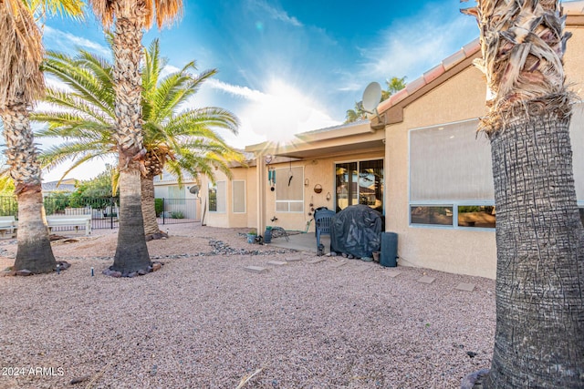 back of house featuring a patio area, fence, and stucco siding