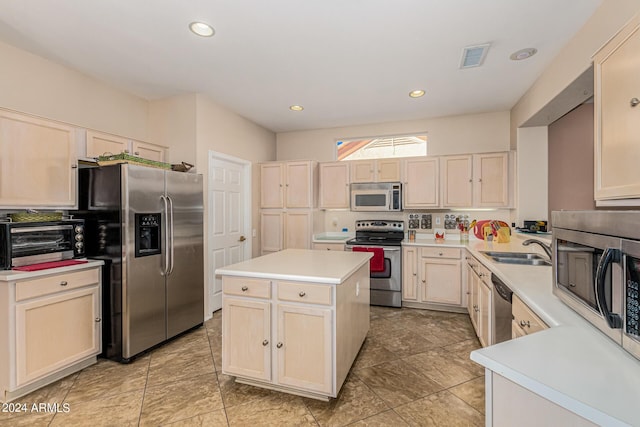 kitchen featuring a toaster, a kitchen island, a sink, light countertops, and appliances with stainless steel finishes