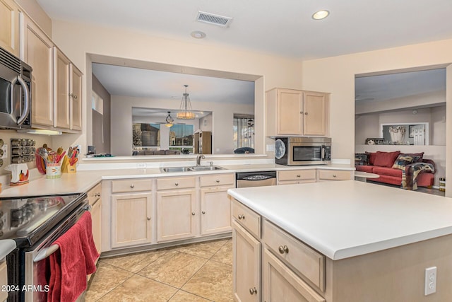 kitchen with light tile patterned floors, stainless steel appliances, a sink, visible vents, and light countertops