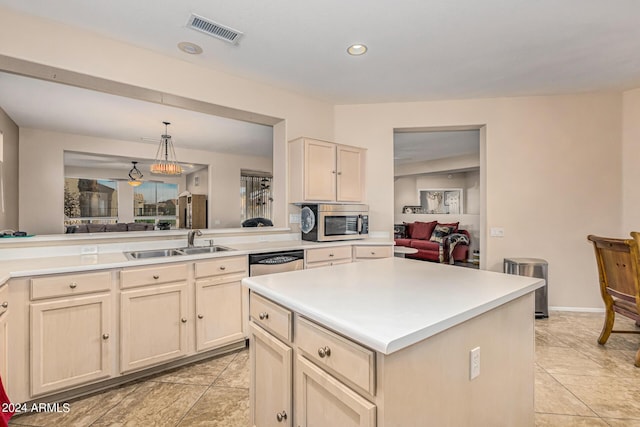 kitchen featuring visible vents, appliances with stainless steel finishes, a center island, light countertops, and a sink