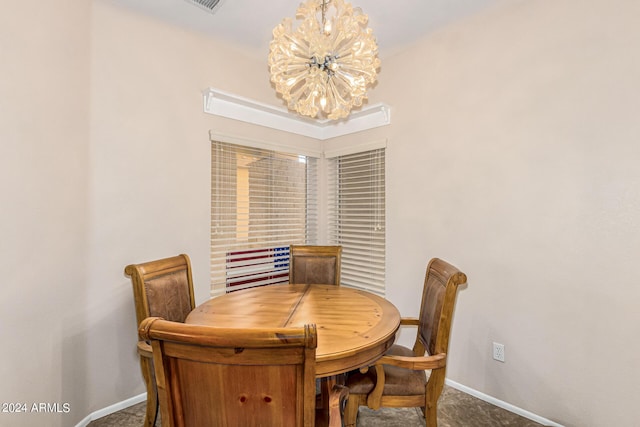 dining room with a chandelier, carpet floors, and baseboards