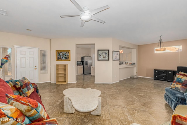 living room with ceiling fan and baseboards