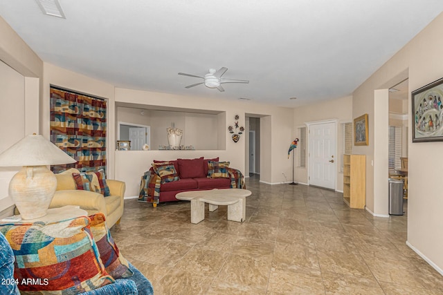 living room with baseboards, visible vents, and a ceiling fan