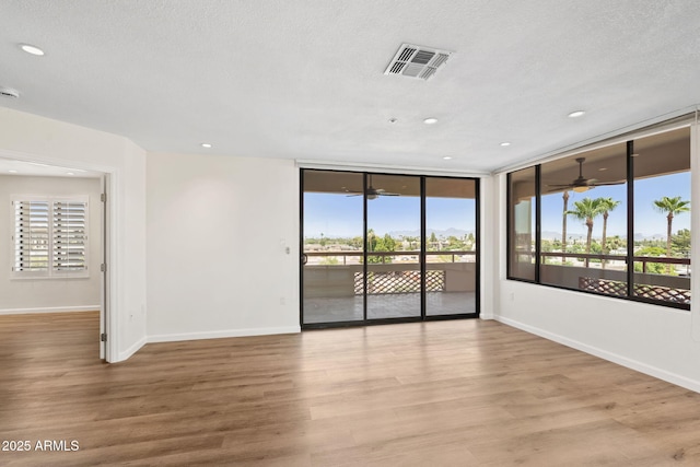 4200 N Miller Rd Unit 504, Scottsdale, AZ 85251 - unfurnished room featuring a ceiling fan, wood finished floors, recessed lighting, and a textured ceiling