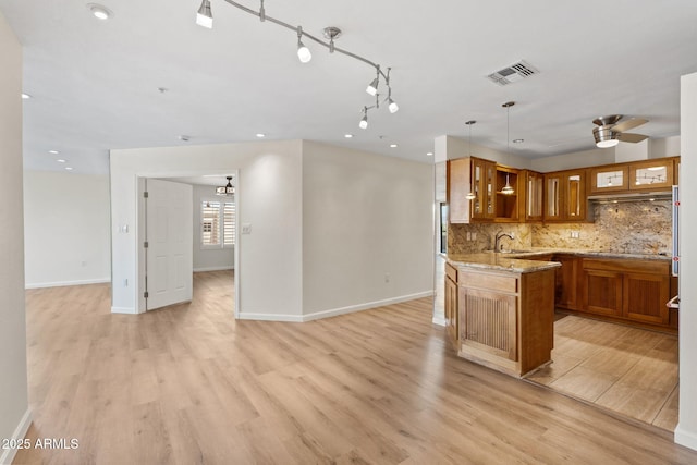 4200 N Miller Rd Unit 504, Scottsdale, AZ 85251 - kitchen with brown cabinets, open floor plan, light wood-type flooring, light stone countertops, and recessed lighting