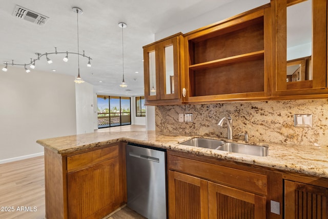 4200 N Miller Rd Unit 504, Scottsdale, AZ 85251 - kitchen with stainless steel dishwasher, brown cabinets, tasteful backsplash, light stone countertops, and light wood finished floors