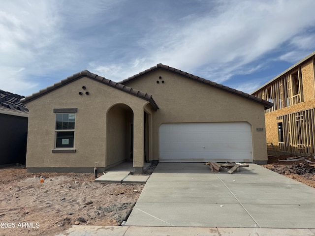 view of front of home featuring stucco siding, concrete driveway, and a garage